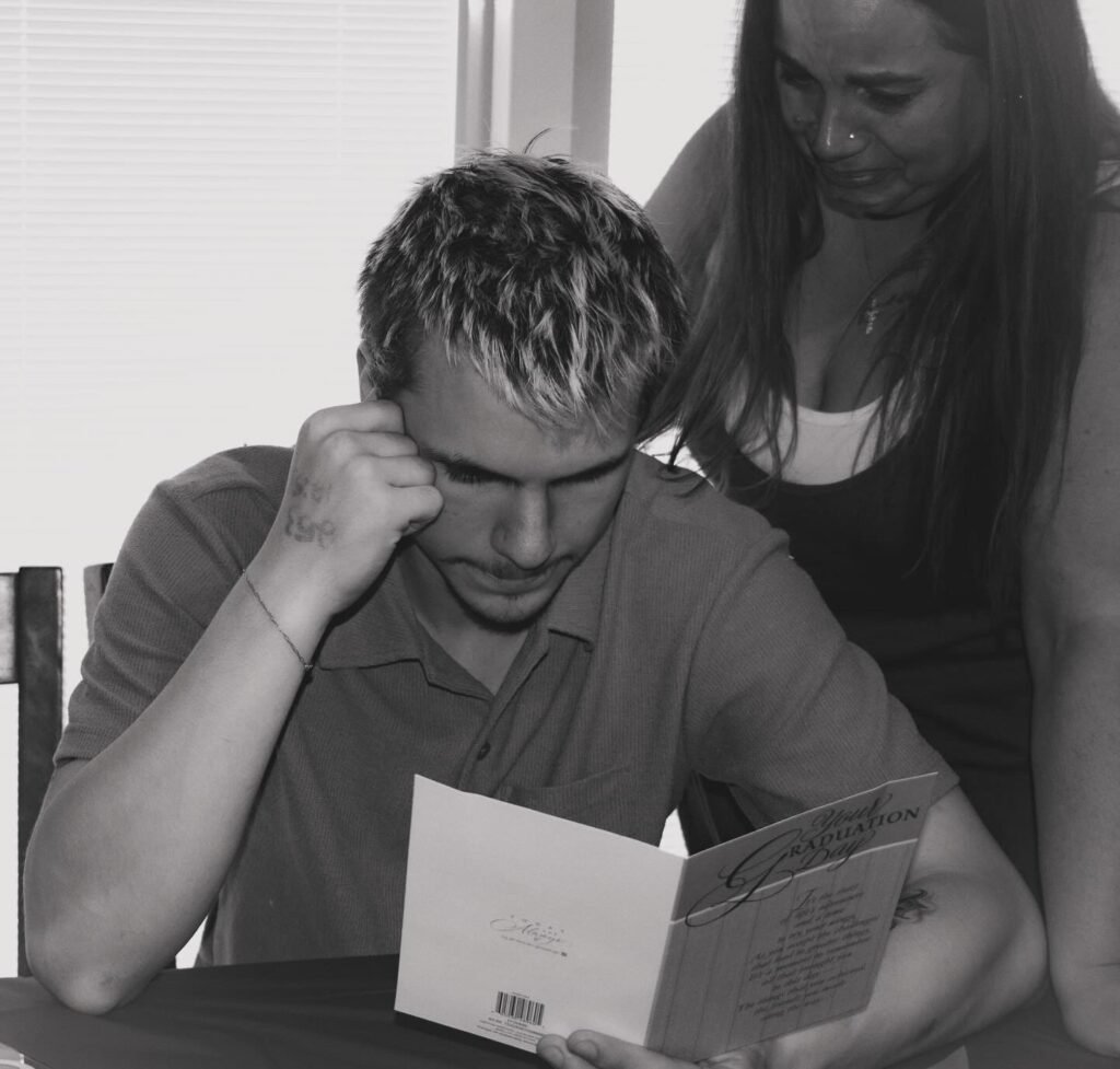 A young woman and a young man reading a greeting card.
