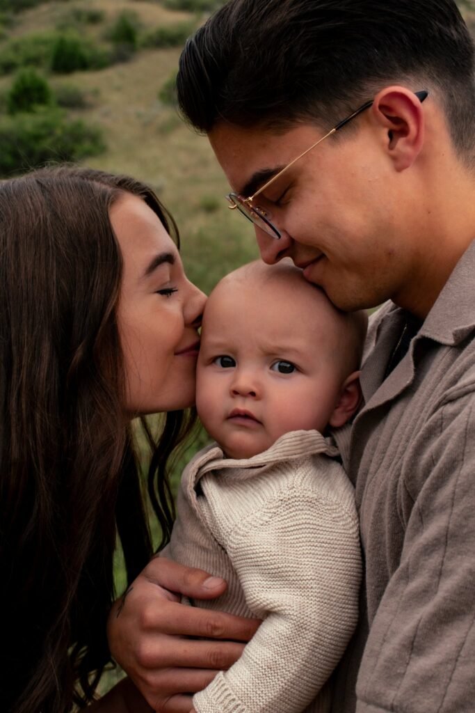 A young man and woman holding their baby between them.