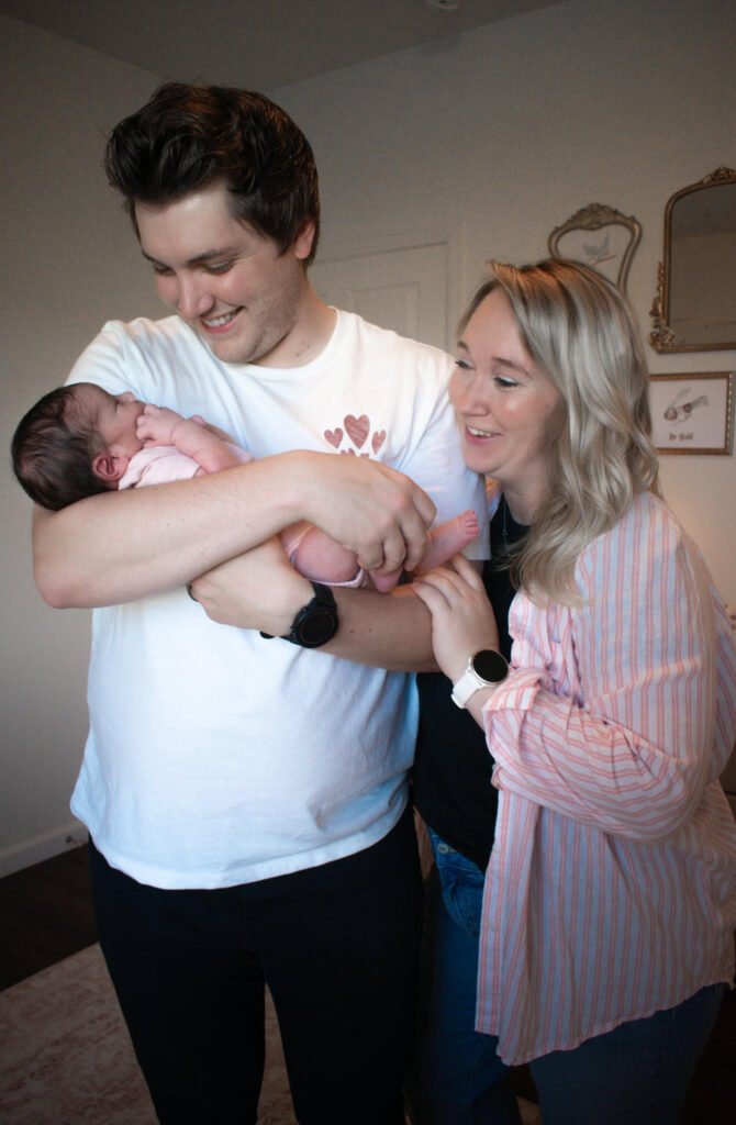 Photo of a young man holding a newborn baby.